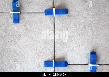 Industrial background. Tile leveling system with plastic clips and wedges, Stock Photo