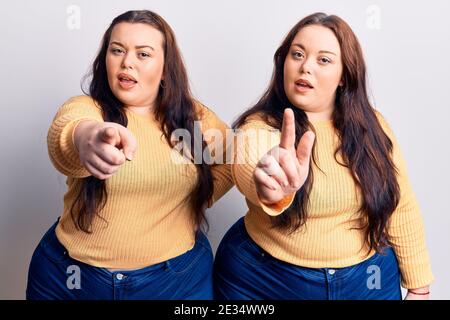 Young plus size twins wearing casual clothes pointing displeased and frustrated to the camera, angry and furious with you Stock Photo