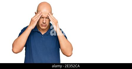 Middle age bald man wearing casual clothes with hand on head for pain in head because stress. suffering migraine. Stock Photo