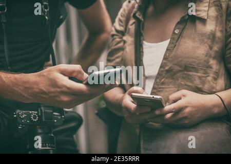 People using mobile phones holding smartphones travel lifestyle. Closeup of hands texting on smart cellphone tech devices tourists woman and man lost Stock Photo
