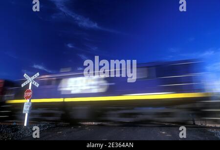 FAST MOVING TRAIN PASSING RAILWAY CROSSING, RURAL NEW SOUTH WALES, AUSTRALIA. Stock Photo