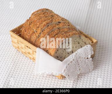 Sliced sesame bread in bamboo basket on white cloth background Stock Photo