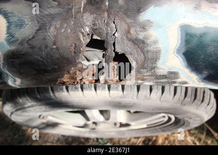 Metal corrosion on a car fender, rust hole. car body repair. Top view. Stock Photo