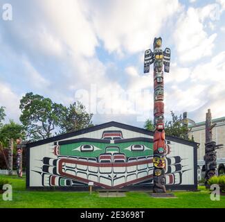 A totem pole and the Mungo Martin House in Thunderbird Park in Victoria ...