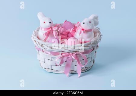 eater eggs with bunny figurines in a wicker basket Stock Photo