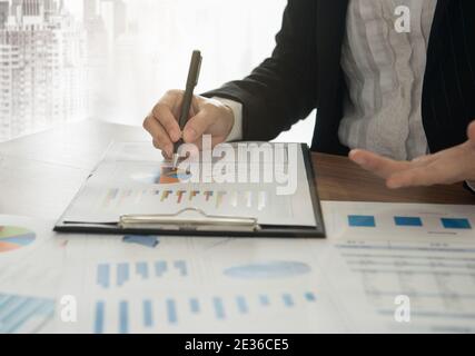 Business woman presenting the chart and graph showing the results of project her team successful. Stock Photo