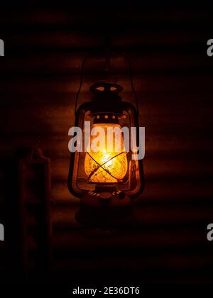 Old kerosene lantern hanging against a corrugated iron wall. Stock Photo