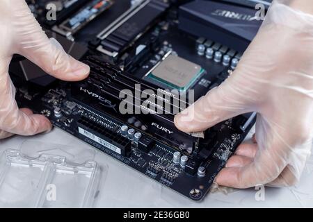 Moscow, Russia -25 Dec 2020: Installing ram memory module on desktop computer motherboard closeup Stock Photo