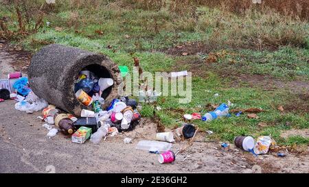 Trash in overloaded inverted garbage can on city street. Ecological problem of environmental pollution. KRYVYI RIH, UKRAINE - NOVEMBER, 2020. Stock Photo