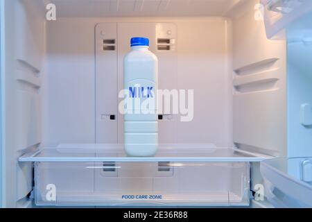 A bottle of milk stands alone in an empty refrigerator Stock Photo