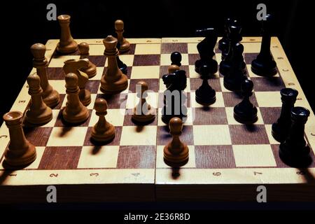 Old pieces in a middlegame position on a shabby chessboard Stock Photo