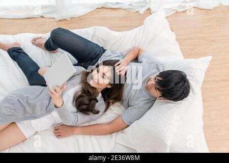 Top view of Lover using the digital tablet at modern home sleeping on the bed, Couple Lover and lifestyle concept Stock Photo