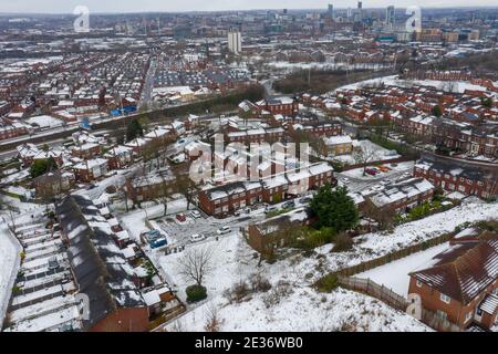 Aerial photo of a snowy day in the city of Leeds in the UK, showing rows of terrace houses with snow covered roofs in the Village of Beeston in the wi Stock Photo