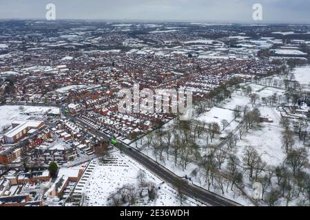 Aerial photo of a snowy day in the city of Leeds in the UK, showing rows of terrace houses with snow covered roofs in the Village of Beeston in the wi Stock Photo