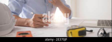 Architect working in office with blueprints,engineer thinking and planning inspection in workplace for architectural plan,sketching a construction pro Stock Photo