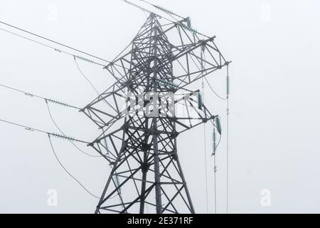 High-voltage lines close-up on a foggy winter day Stock Photo