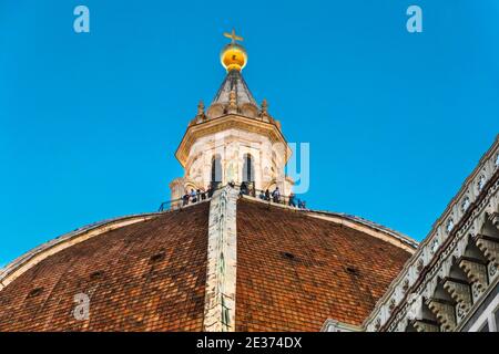 Beautiful close-up view of Florence Cathedral's Dome with the cupola on top where visitors are standing. The cupola, crowned with a gilt copper ball... Stock Photo