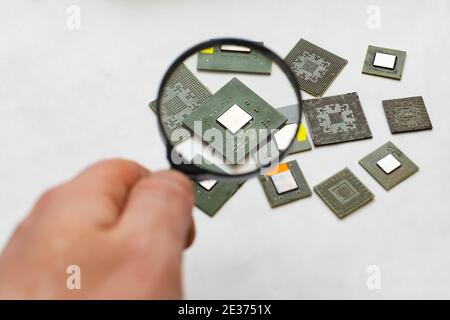 computer chip, a microprocessor that a person views through a magnifying glass Stock Photo