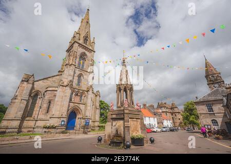 Falkland, Scotland - July 2 2017: The Bruce Fountain and Falkaland Parish Church in the quaint village of Falkland in Fife, Scotland. Stock Photo