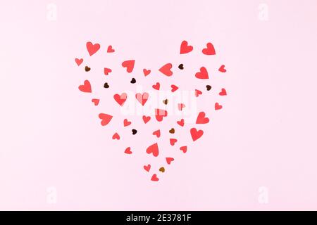 Heart shape made of red hearts and sequins on a pink background greeting card for valentine's day Stock Photo