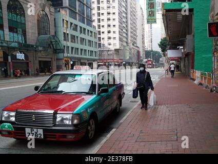 Hong Kong, China. 17th Jan, 2021. A woman wearing a face mask walks on a street in Hong Kong, south China, Jan. 17, 2021. Hong Kong's Center for Health Protection (CHP) reported 55 additional confirmed cases of COVID-19 on Sunday, taking its total tally to 9,557. The new cases included 51 local infections, of which 16 had an unknown origin, according to a CHP press briefing. There were also more than 80 cases tested positive preliminarily. Credit: Li Gang/Xinhua/Alamy Live News Stock Photo