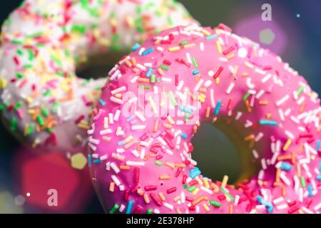 Delicious and sweet donuts with different glaze and different flavors, with rays of light falling on them Stock Photo