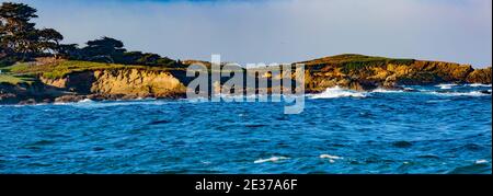 Pebble Beach, California, February 17, 2018:  Panorama view of Fan shell Beach with the Cypress Point Golf Course in the background. Stock Photo