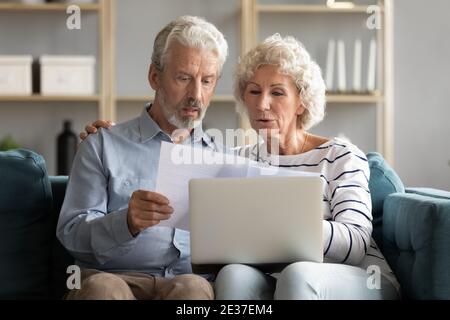 Happy elderly senior family couple reading letters. Stock Photo