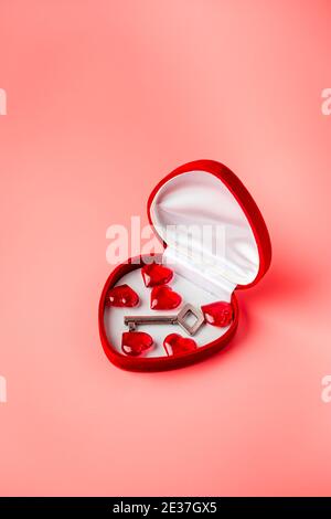 Key in a box of heart shape as a symbol of love. Valentines day background. Greeting card with red heart on pink background Stock Photo