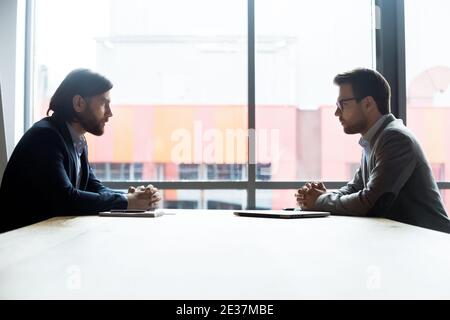 Concentrated two businessmen involved in negotiating contract. Stock Photo