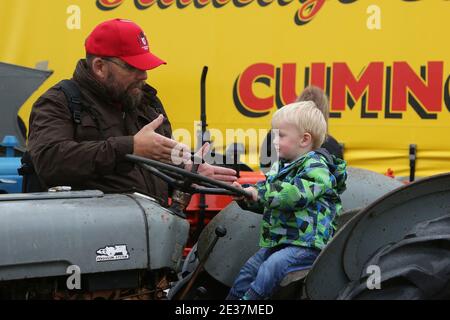 Scottish International Airshow . Sunday 4th Sept 2017 .Low Green, Ayr, Ayrshire, Scotland, UK . A wet afternoon at the airshow. Father & son on a vintage tractor Stock Photo