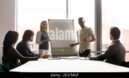 Happy two young mixed race speakers presenting marketing research results. Stock Photo