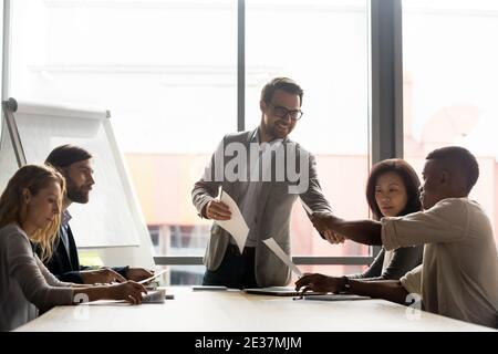 Smiling young male ceo executive manager analyzing data with colleagues. Stock Photo