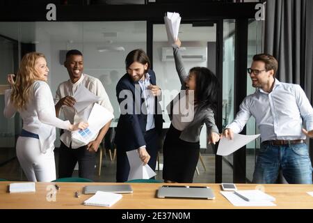 Overjoyed happy young and senior multiracial business people having fun. Stock Photo