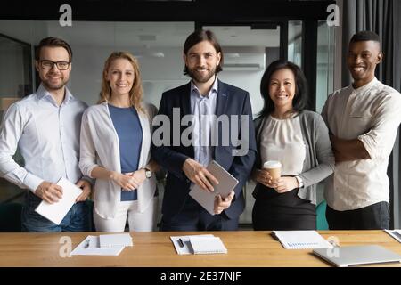 Portrait of smiling confident young and middle aged diverse workers. Stock Photo