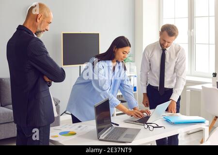 Creative group of diverse business colleagues working with laptop in modern office. Stock Photo