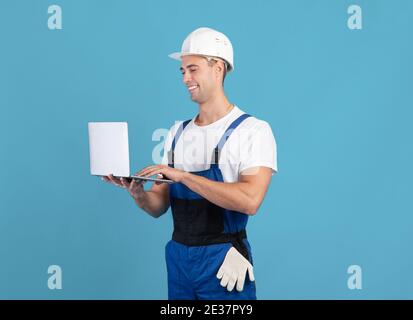 Handsome Young Foreman Guy With Laptop, Ordering Construction Materials Online Stock Photo