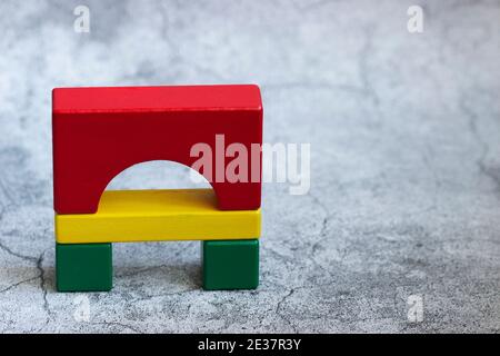 Colorful wooden details of the constructor on a gray background. Stock Photo
