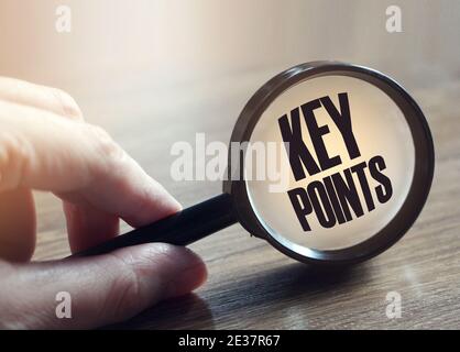 Magnifying glass with text KEY POINTS on wooden table. Stock Photo