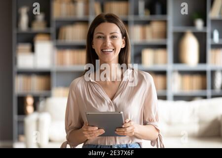 Head shot portrait smiling woman holding computer tablet in hands Stock Photo