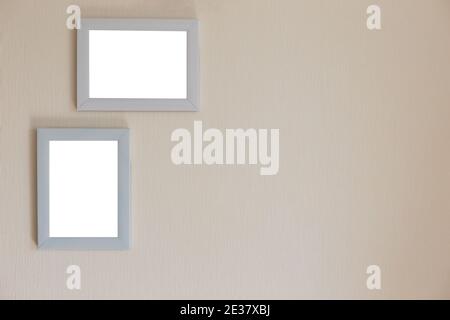 Two white frames on a beige wall Stock Photo