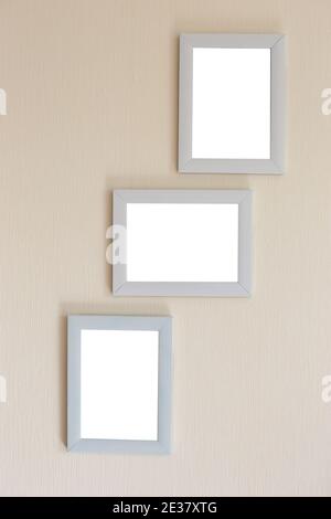 Collage of three white frames on a beige wall Stock Photo