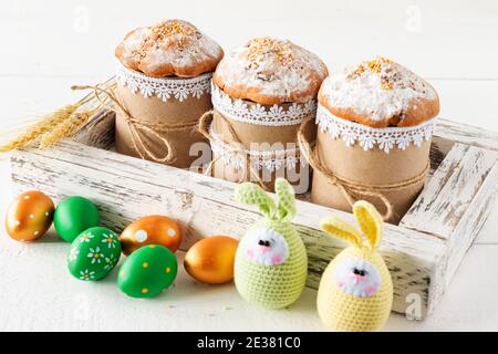 Arrangement decoration Happy Easter holiday background concept. Easter cakes in wooden box with handmde knitted eggs. Pastel colors Stock Photo