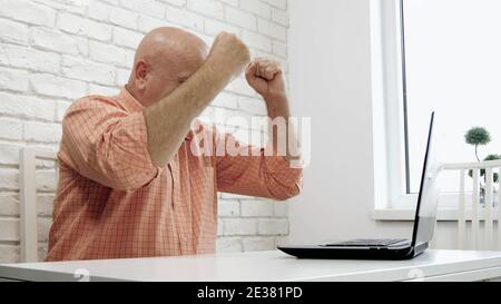 Image with an Upset and Disappointed Businessman Using a Laptop Stock Photo