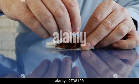Smoker Roll a Handmade Cigarette Using Cigarette Paper a Filter and Tobacco Stock Photo