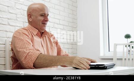 Image with a Satisfied Businessman in Office Room Closing the Laptop and Smiling Happy Stock Photo