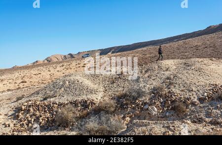 a scientist explores a mound above what appears to be a prehistoric site at the west end of the makhtesh ramon crater in israel Stock Photo