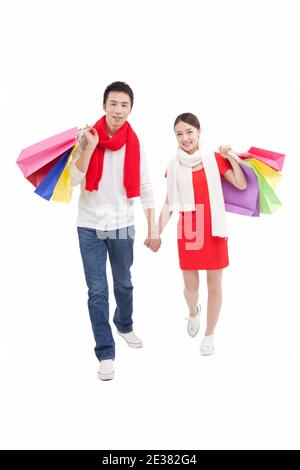 Portrait of young couple holding shopping bags over shoulders,hand in hand Stock Photo