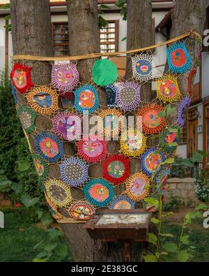 Crochet woven around tree trunk. Stock Photo
