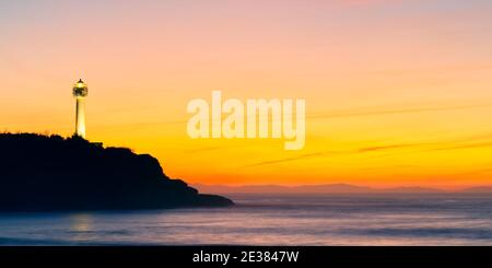 sunset over Biarritz lighthouse, Basque country, France. Waves with long exposure. Stock Photo